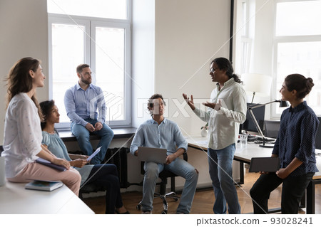 Indian business trainer makes speech during briefing in coworking office Indian business trainer makes speech during briefing in coworking office 93028241