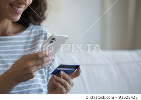 Happy smartphone user woman holding credit card Happy smartphone user woman holding credit card 93028428