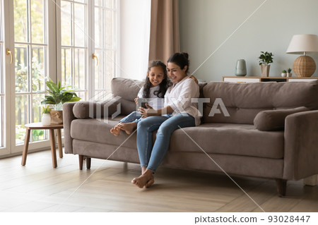 Happy Indian mom and kid taking selfie on mobile phone Happy Indian mom and kid taking selfie on mobile phone 93028447