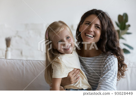 Happy joyful young mom hugging pretty little daughter Happy joyful young mom hugging pretty little daughter 93028449