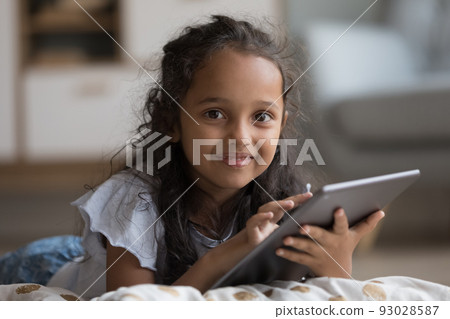 Happy sweet gen Z little kid girl holding tablet computer Happy sweet gen Z little kid girl holding tablet computer 93028587