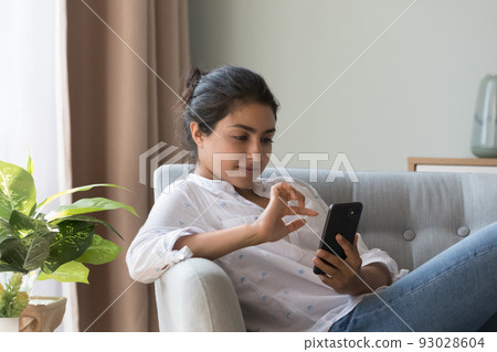 Thoughtful satisfied millennial Indian girl using online shopping app Thoughtful satisfied millennial Indian girl using online shopping app 93028604