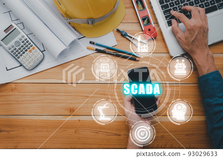 SCADA Supervisory control and data acquisition technology concept, Man hand usind smart phone with SCADA icon on virtual screen. SCADA Supervisory control and data acquisition technology concept, Man hand usind smart phone with SCADA icon on virtual screen. 93029633