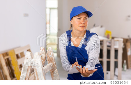 Portrait of a woman engineer making notes on paper Portrait of a woman engineer making notes on paper 93031664