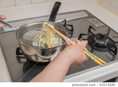 [Middle housewife boil ramen noodles with chopsticks and bamboo basket] 93033890