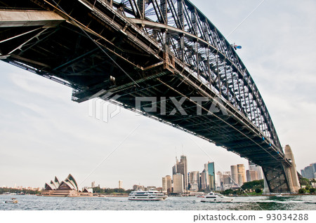 SYDNEY, AUSTRALIA - APRIL 13, 2019: Sydney Harbour Bridge with Opera House far away in Sydney Harbour Australia SYDNEY, AUSTRALIA - APRIL 13, 2019: Sydney Harbour Bridge with Opera House far away in Sydney Harbour Australia 93034288
