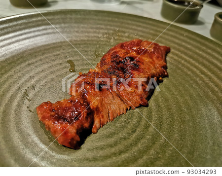 Grilled beef piece from BBQ charcoal Brazilian style (Churrasco) on green dish 93034293