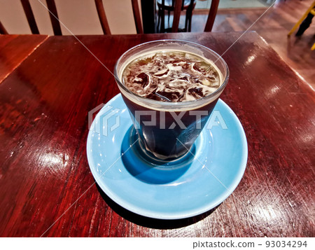 Cold brew iced fresh Americano coffee served in a glass on wooden table Cold brew iced fresh Americano coffee served in a glass on wooden table 93034294