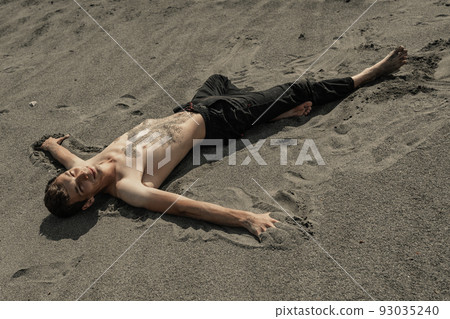 Man lying on sand in desert 93035240