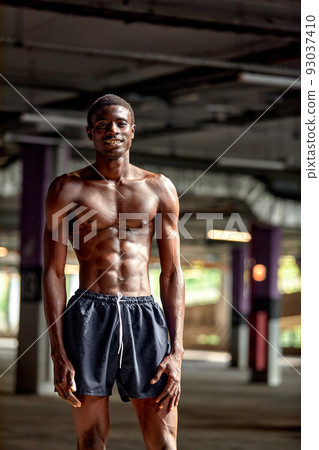 Handsome afro American sportman standing on the street while taking break after training. Black male having rest after workout Handsome afro American sportman standing on the street while taking break after training. Black male having rest after workout 93037410