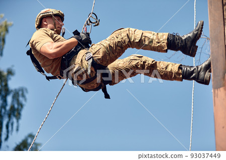 Special forces fighter descends from a skyscraper to storm the apartment. SWAT, police, counter terrorism concept. Mixed media Special forces fighter descends from a skyscraper to storm the apartment. SWAT, police, counter terrorism concept. Mixed media 93037449