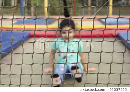Little girl having fun on trampoline at park outdoors area Little girl having fun on trampoline at park outdoors area 93037933
