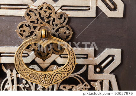 Vintage handle on an old oriental wooden door Vintage handle on an old oriental wooden door 93037979