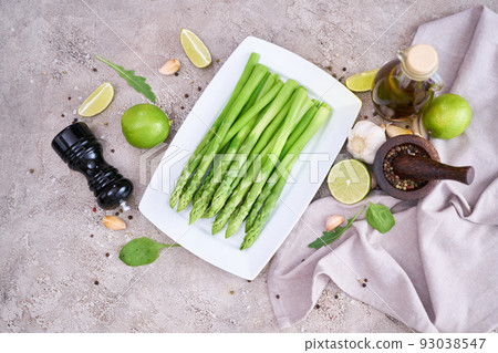Green organic natural Asparagus in ceramic white plate on kitchen table Green organic natural Asparagus in ceramic white plate on kitchen table 93038547