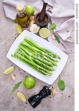 Green organic natural Asparagus in ceramic white plate on kitchen table Green organic natural Asparagus in ceramic white plate on kitchen table 93038548