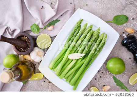Green organic natural Asparagus in ceramic white plate on kitchen table 93038560
