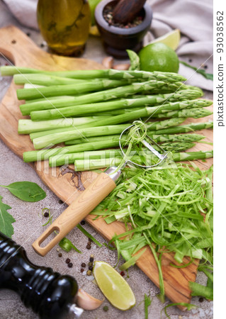 Green organic natural Asparagus on wooden cutting board at kitchen table 93038562
