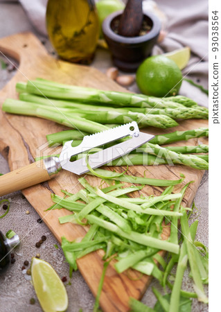Green organic natural Asparagus on wooden cutting board at kitchen table 93038564