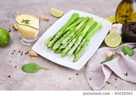 Green organic natural Asparagus in ceramic white plate on kitchen table 93038565