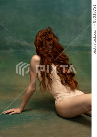 Portrait of sensual beautiful redhead girl with long curly hair. Gorgeous hair and deep green eyes. Concept of beauty, art, fashion, health and wellbeing 93039751