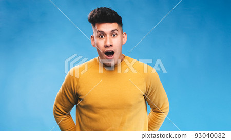 Man looking at camera with a shocked expression on his face while standing over an isolated background. Man looking at camera with a shocked expression on his face while standing over an isolated background. 93040082
