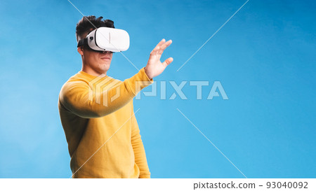 Man using VR headset while experiencing the virtual reality over an isolated background. 93040092