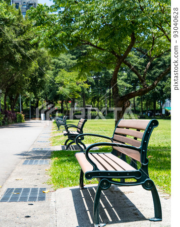 Summer park, green lanes, walking paths, park benches under trees, sunny days. 93040628