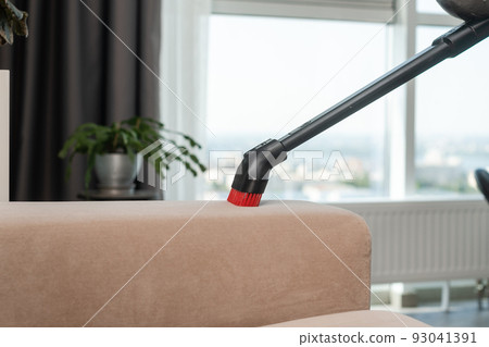 Close-up of sofa cleaning with vacuum cleaner. Close-up of sofa cleaning with vacuum cleaner. 93041391