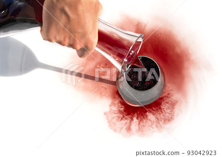 Sommelier pours red wine from decanter to wineglass on white background. Sommelier pours red wine from decanter to wineglass on white background. 93042923