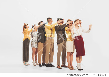 Group of young stylish people standing in a line, covering each other eyes, posing isolated over white studio background 93043321