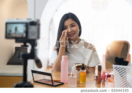 Young beautiful Asian woman and professional beauty make up artist vlogger or blogger recording makeup tutorial to share on website or social media. Business online influencer on social media concept. 93044195