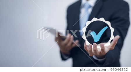 Quality assurance of business services, Businessman Hand shows the sign of the top service Quality assurance in Black background , Guarantee, Standards, ISO certification and standardization concept. 93044322