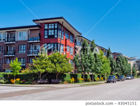 Red residential building on a street corner with cars parked beside Red residential building on a street corner with cars parked beside 93045151