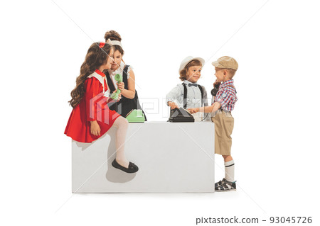 Group of cheerful kids, little boys and girls in retro style summer outfit playing with vintage phones isolated on white background. Concept of friendship 93045726