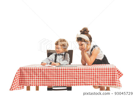 Dinner conversation. Cute two little kids, boy and girl in retro american style outfits like family couple isolated on white background. Comparison concept Dinner conversation. Cute two little kids, boy and girl in retro american style outfits like family couple isolated on white background. Comparison concept 93045729