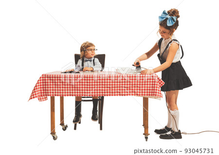 Cute two little kids, boy and girl in retro american style outfits like family couple isolated on white background. Comparison concept 93045731