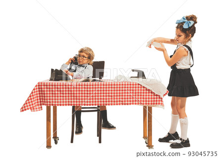 Creative composition with two little kids, boy and girl in retro american style outfits like family couple isolated on white background. Comparison concept Creative composition with two little kids, boy and girl in retro american style outfits like family couple isolated on white background. Comparison concept 93045735