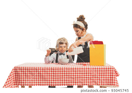 Creative composition with two little kids, boy and girl in retro american style outfits like family couple isolated on white background. Comparison concept Creative composition with two little kids, boy and girl in retro american style outfits like family couple isolated on white background. Comparison concept 93045745