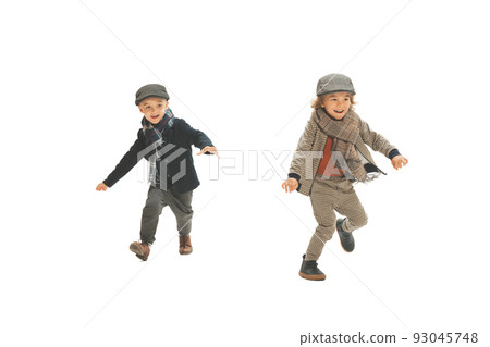 Catch-up. Two preschool age boys, fashionable kids wearing autumn retro clothes strolling isolated over white background. Concept of childhood Catch-up. Two preschool age boys, fashionable kids wearing autumn retro clothes strolling isolated over white background. Concept of childhood 93045748