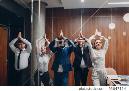 Businessman and businesswoman team doing warm up and yoga exercises before office meeting. Business healthy successful people group man and woman after conference discussion with boss. Businessman and businesswoman team doing warm up and yoga exercises before office meeting. Business healthy successful people group man and woman after conference discussion with boss. 93047134