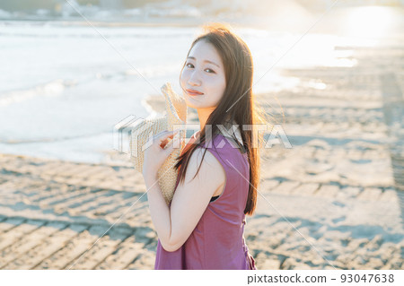 一個戴著草帽在沙灘上玩耍的女人 一個戴著草帽在沙灘上玩耍的女人 93047638