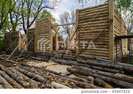 traditional wooden house peeled log wall during cobntruction process with diagonal props traditional wooden house peeled log wall during cobntruction process with diagonal props 93047828