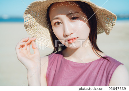 戴著草帽在沙灘上玩耍的女人 戴著草帽在沙灘上玩耍的女人 93047889