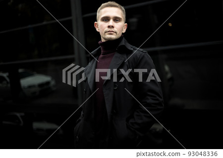 Ukrainian man in black trenchcoat and purple polo 93048336