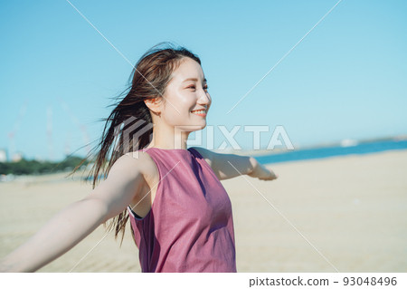 One-piece young woman playing at the seaside under the blue sky One-piece young woman playing at the seaside under the blue sky 93048496