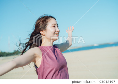 One-piece young woman playing at the seaside under the blue sky One-piece young woman playing at the seaside under the blue sky 93048497
