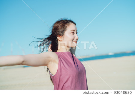 A young woman in a dress staring at the sea 93048680