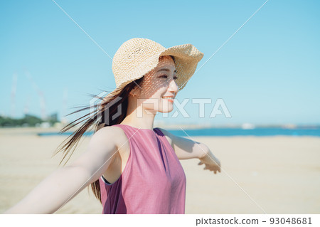 A young woman in a dress staring at the sea A young woman in a dress staring at the sea 93048681