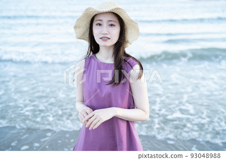 戴草帽的年輕女子在沙灘上玩耍 93048988