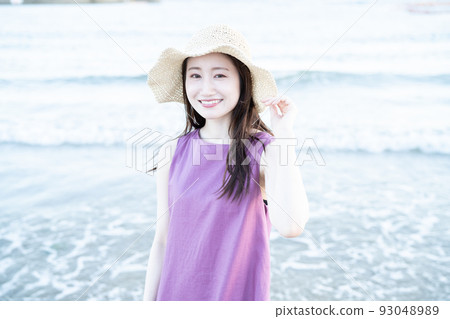 戴草帽的年輕女子在沙灘上玩耍 93048989
